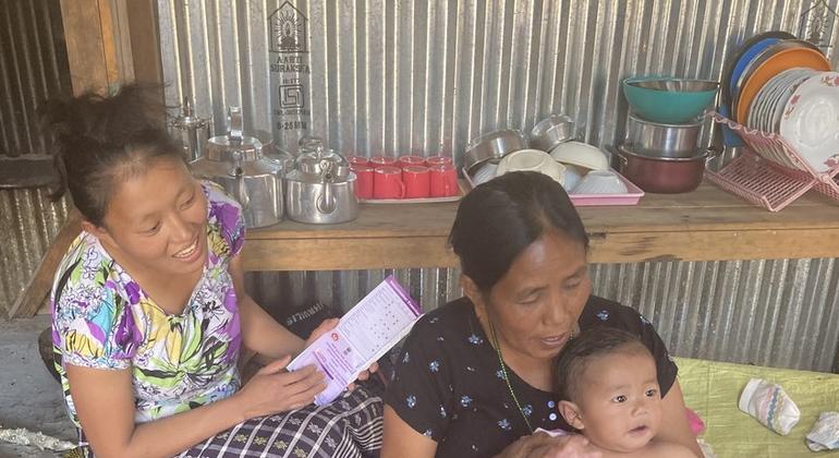 मणिपुर के कामजोंग ज़िले के पाबुंग गाँव में, बच्चे की माँ टीकाकरण कार्ड लेकर आ रही हैं, और आशा कार्यकर्ता, अलंगवोन, टीकाकरण के बाद बच्चे के साथ खेल रही हैं.