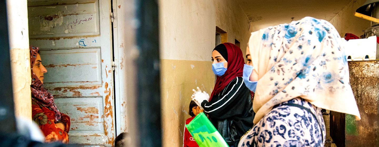 Voluntarios respaldados por UNICEF hablan con una familia sobre las medidas preventivas para detener la propagación de COVID-19 en Hassakeh, Siria.