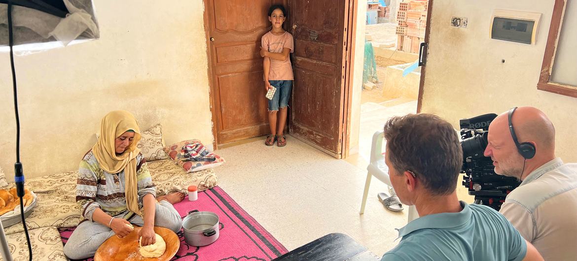 Najwa Selmi kızıyla birlikte evde, bir UNTV film ekibine geleneksel 'tabuna' ekmeğinin nasıl yapıldığını gösteriyor.