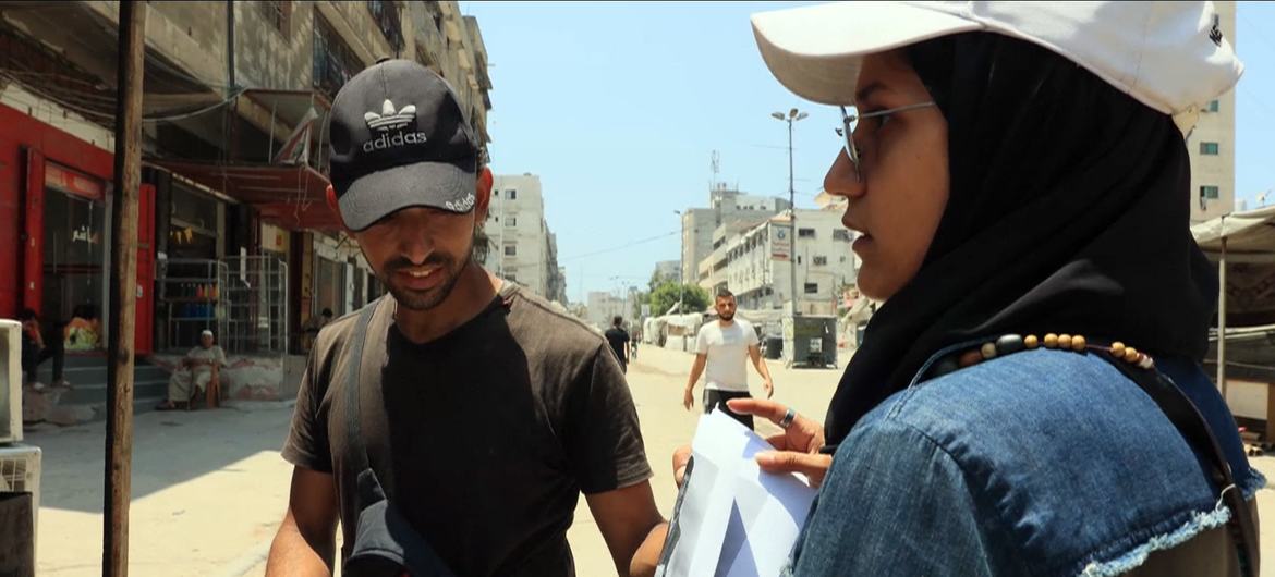Anwar Hawas pregunta a la gente en la calle si tienen alguna información sobre su hermano desaparecido, después de mostrarle sus fotos.