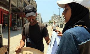 Anwar Hawas pregunta a la gente en la calle si tienen alguna información sobre su hermano desaparecido, después de mostrarle sus fotos.