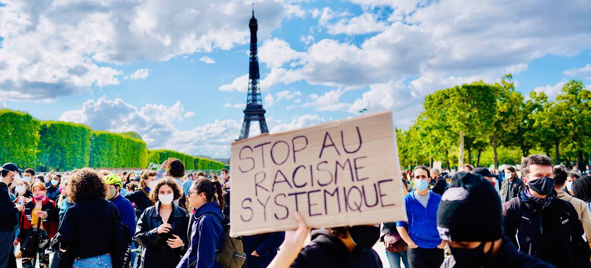 在法国巴黎一场反对警察暴力的抗议活动中，一名抗议者举着的标语牌写着“停止系统性种族主义”。（摄于2020年6月）