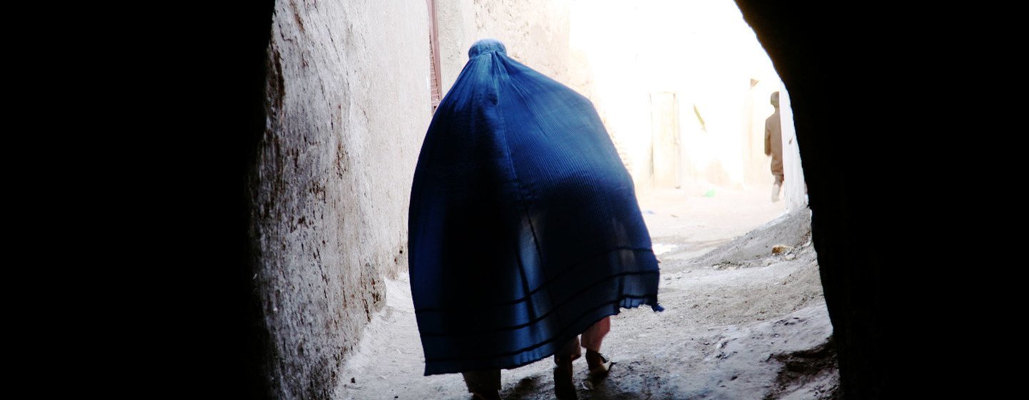 Une Afghane vêtue d'une burqa bleue traverse une ruelle étroite à Hérat.