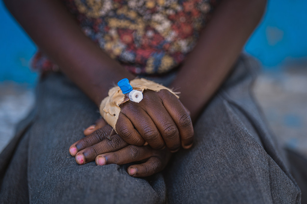 Primer plano de la mano de una niña con una vía intravenosa, tomada en un centro de tratamiento del cólera en Kihumba, zona sanitaria de Idjwi, Kivu del Sur, República Democrática del Congo.