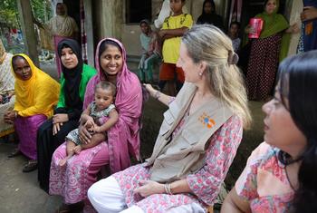 Anima Akhter, 24, proudly introduces her seven-month-old son to UNFPA Representative Catherine Breen Kamkong during a community visit to Bodipur village. 