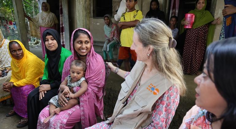 Anima Akhter, 24, proudly introduces her seven-month-old son to UNFPA Representative Catherine Breen Kamkong during a community visit to Bodipur village. 