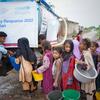 Children displaced by floods wait to collect safe drinking water in Pakistan.