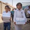 Displaced children carry hygiene kits distibuted by UNICEF in Marib, Yemen.