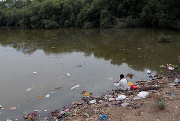 A man fishes on the banks of the Mithi River in western India that has become an open dump for sludge oil and hazardous chemicals.