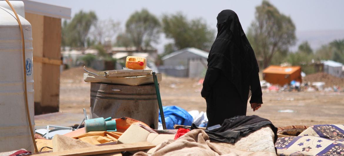 A woman in Yemen walks through an area devastated by floods.