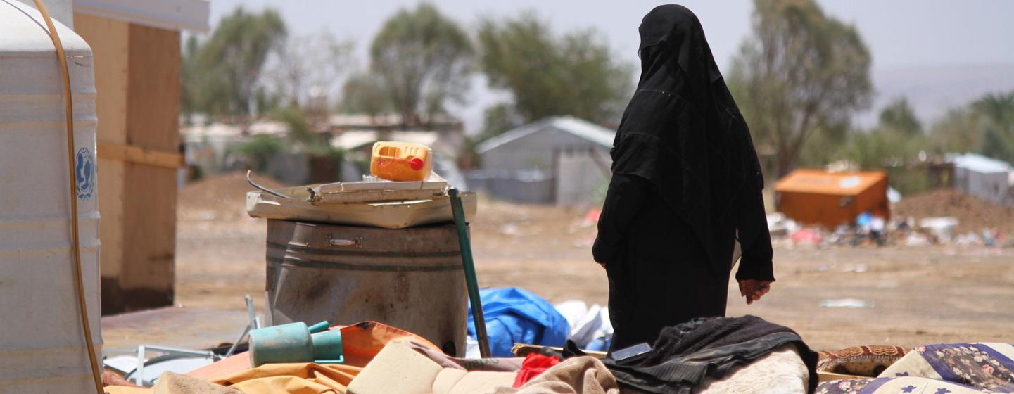 Une femme au Yémen traverse une zone dévastée par les inondations.