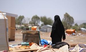 A woman in Yemen walks through an area devastated by floods.