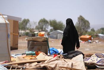 A woman in Yemen walks through an area devastated by floods.