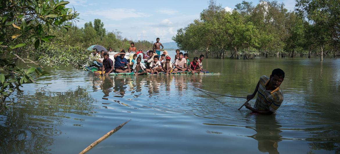 Rohingya refugees cross the Naf River on a makeshift raft while fleeing violence in Myanmar, on their way to Bangladesh in 2017. Rohingya refugees cross the Naf River on a makeshift raft while fleeing violence in Myanmar, on their way to Bangladesh in 2017.