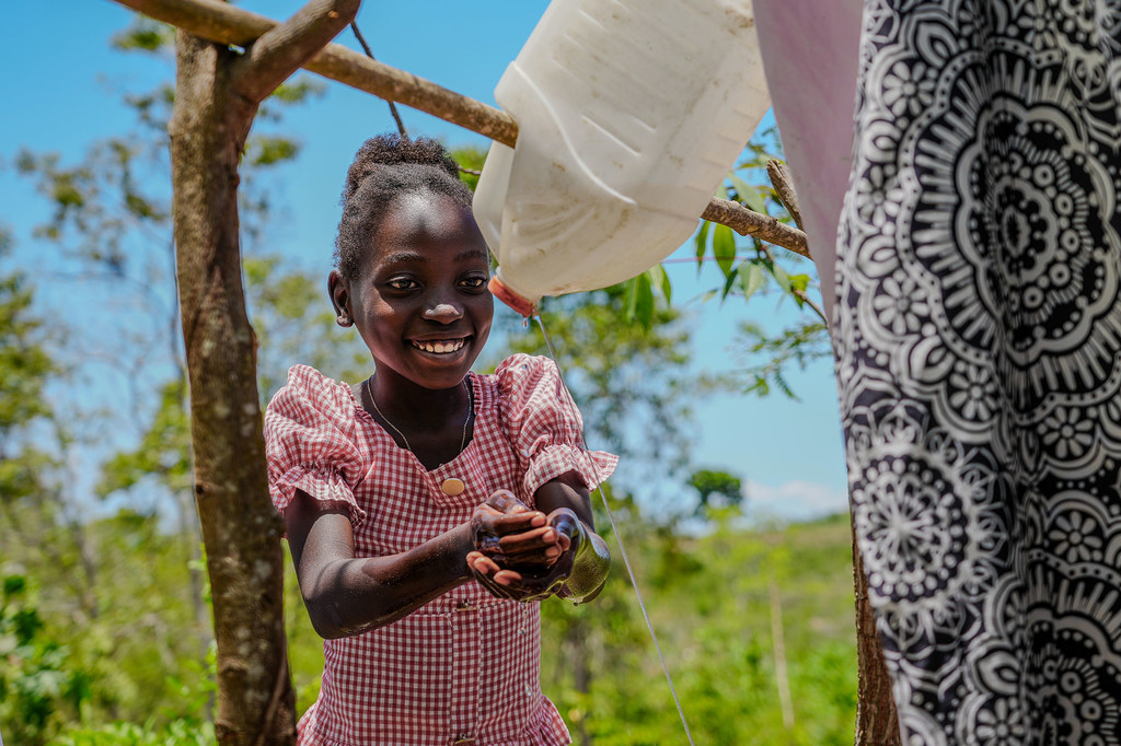 En Haïti, Noel-Dina se lave les mains après avoir utilisé une latrine construite par sa mère.
