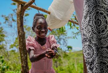 Noel-Dina se lava las manos después de usar la letrina que construyó su madre.