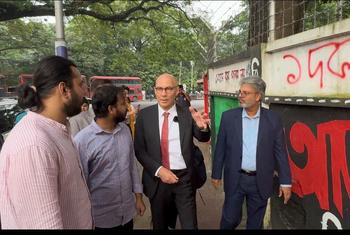 High Commissioner for Human Rights Volker Türk with students showing the grafitti made during the July protest near the Dhaka University, Bangladesh.