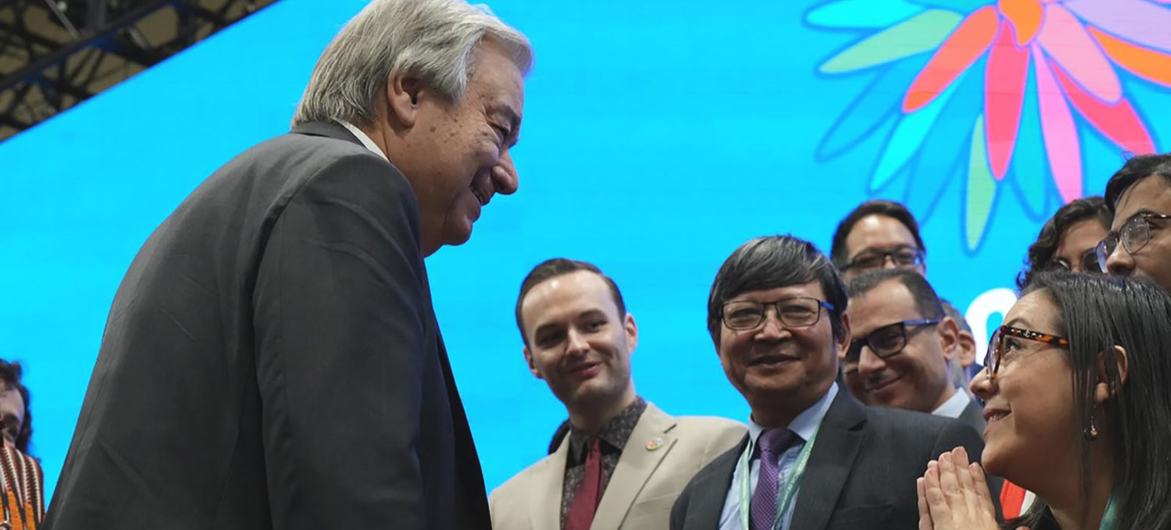 El secretario general de la ONU , António Guterres, sonríe mientras interactúa con los delegados en una conferencia.