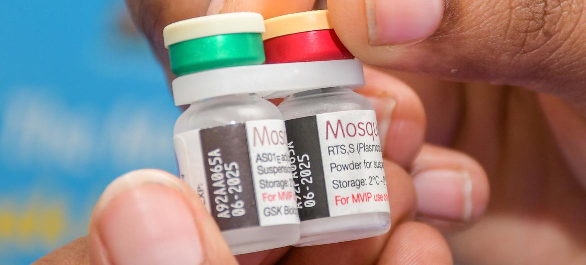 A health worker in Kenya holds vials of malaria vaccine to be administered at a vaccination campaign.
