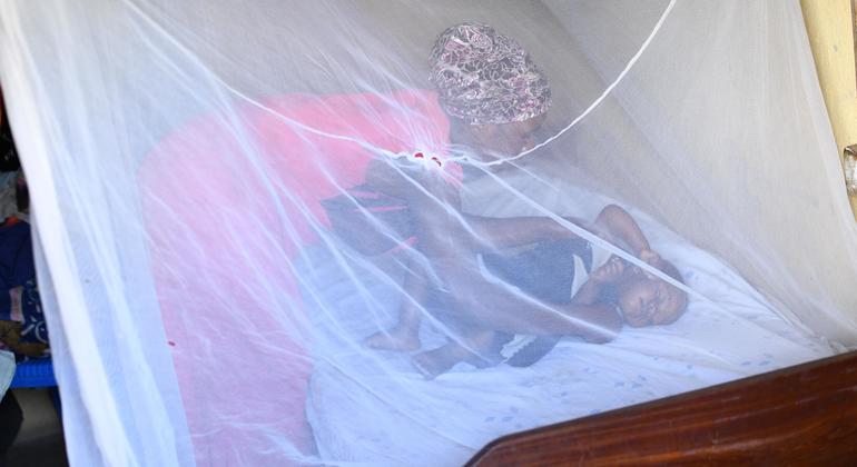 Dans l'Ouganda rural, une mère couche son enfant d'un an dans une moustiquaire.