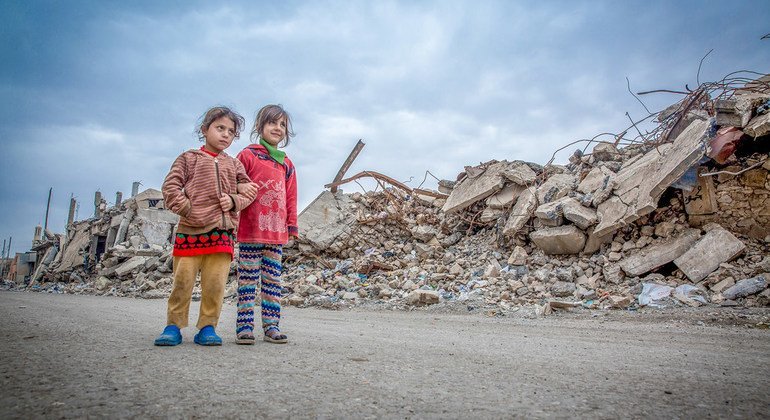 Two girls are wandering around the ruins of Mosul City in Iraq.