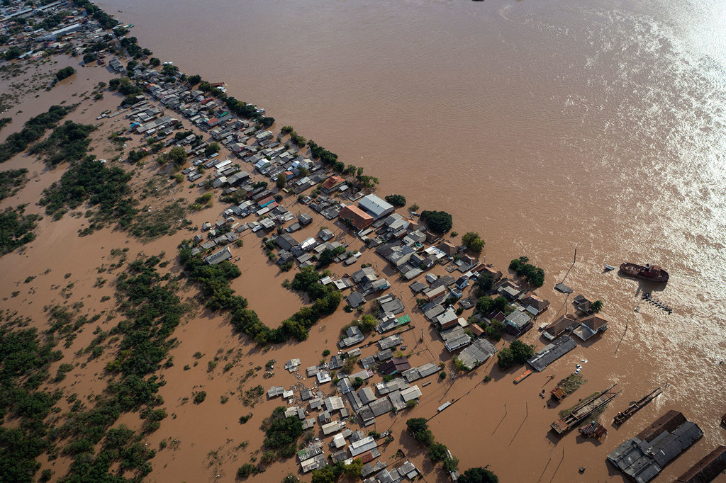 Vista aérea de un barrio inundado en Canoas, Brasil, con casas y calles sumergidas en las aguas fangosas del río Guaíba.