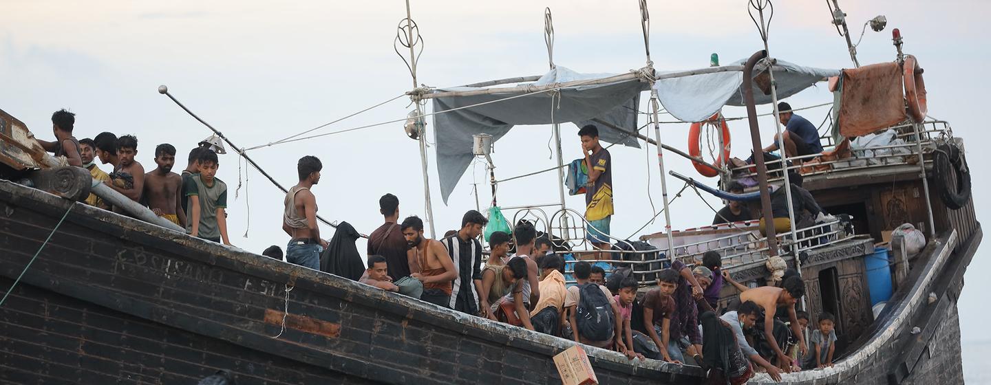 Refugiados rohingyas que chegam a Ulee Madon, no norte de Aceh, na Indonésia, vindos do Bangladesh, descarregando seus pertences de um barco.