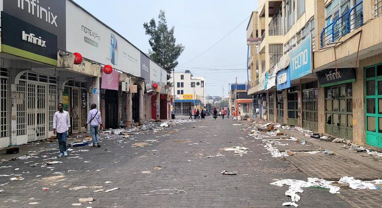 A scattering of people walk through a commercial district in Goma.