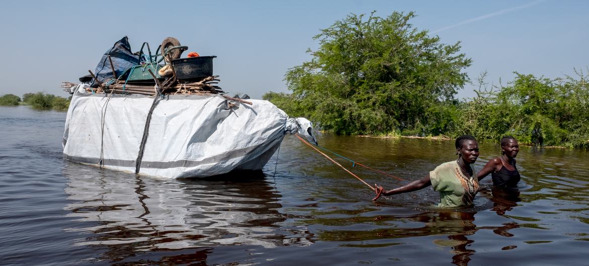 Une famille transporte ses biens hors d'une zone inondée à Bentiu, au Sud-Soudan.