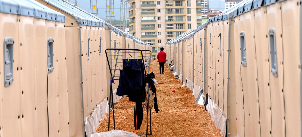 Une personne marche dans un camp pour personnes déplacées à Hatay, en Türkiye.