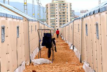 तुर्कीये के हताए में विस्थापितों के लिए बनाए गए एक शिविर से एक व्यक्ति गुज़र रहा है.