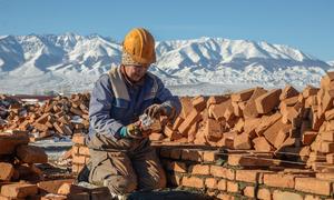Lacking access to open seas, landlocked countries must rely on other nations for imports and exports. Pictured here, a woman constructs a house in Mongolia. 