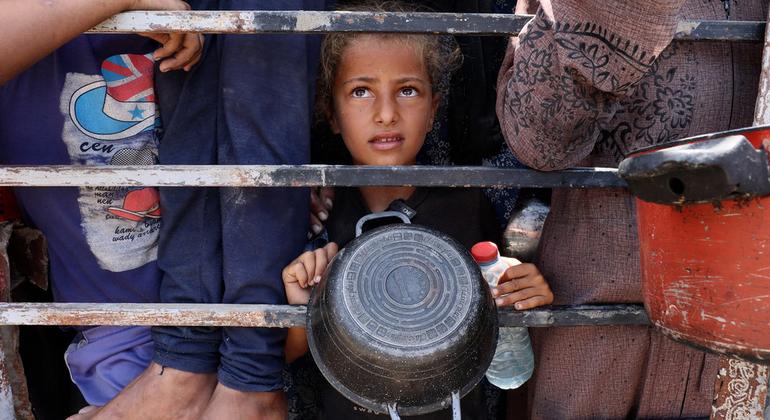 طفلة صغيرة من غزة تنتظر دورها للحصول على وجبة من حساء العدس.