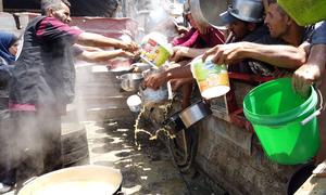 Un grupo de palestinos desplazados se reúne frente a un comedor comunitario en el oeste de la ciudad de Gaza.