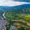 Vue aérienne d'une ville dans une vallée, avec une rivière qui traverse le paysage, entourée de collines verdoyantes et de montagnes dans le Norte de Santander, en Colombie.