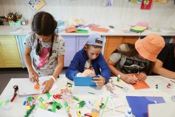 یوکرین میں موسم گرما کی تعطیلات کے دوران یونیسکو کے تحت متعارف کرائے گئے ایک کیمپ میں بچے آرٹ کرنے میں مصروف ہیں۔