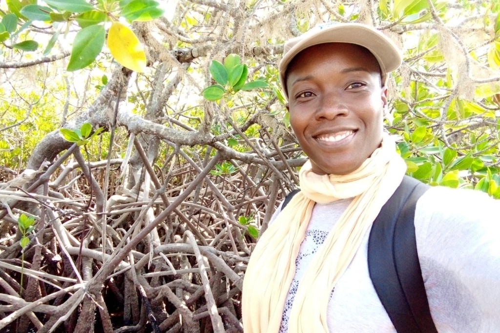 A ecologista Célia Macamo sorri em um manguezal em Moçambique.