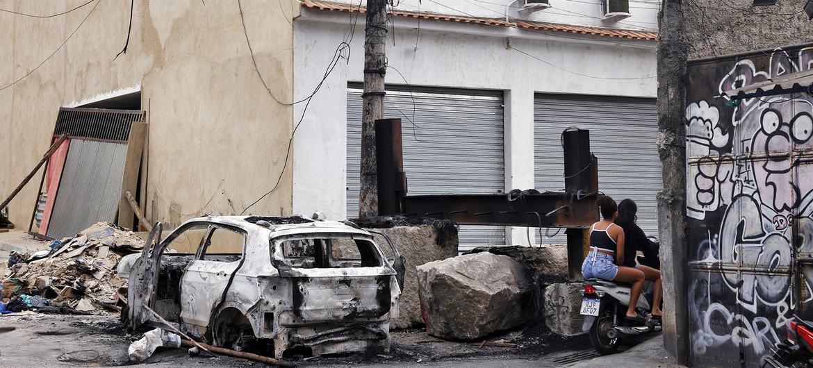 Pessoas passam em moto na praça da Vila Cruzeiro ao lado de barricadas que foram colocadas para conter avanço de policiais durante operação que deixou cerca de 120 mortos