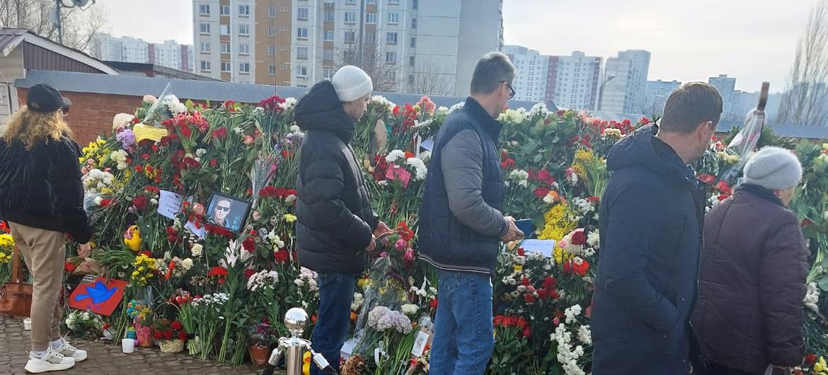 Люди возлагают цветы на могилу Алексея Навального.
