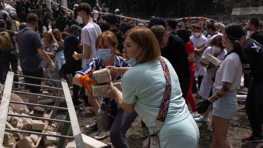 Украинцы собирают обломки и мусор после ракетного удара по Киеву.