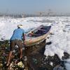 一名男子站在印度被污染的亚穆纳河边。