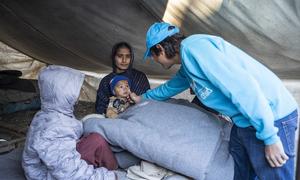Afisa Mawasiliano wa UNICEF - Moeed Hussain akiipa familia blanketi wakati wa usambazaji wa vifaa vya majira ya baridi vya UNICEF katika Kijiji cha Zangi Brohi, Wilaya ya Dadu, Sindh, Pakistan.