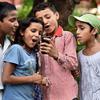 Children at St. Columba’s School, Delhi, India, use a mobile phone
