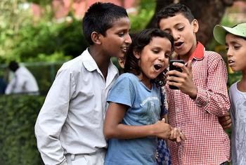 ल्ली, भारत के बच्चे मोबाइल फोन का उपयोग करते हैं