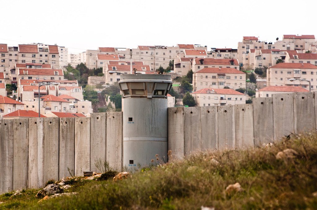 El Muro de Separación en el Territorio Palestino Ocupado y detrás un asentamiento israelí.
