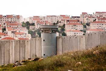 El Muro de Separación en el Territorio Palestino Ocupado y detrás un asentamiento israelí.