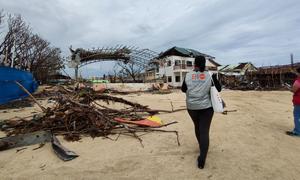 A UNFPA staff member walks to a damaged health centre in General Santos on the island of Mindanao in the Philippines.