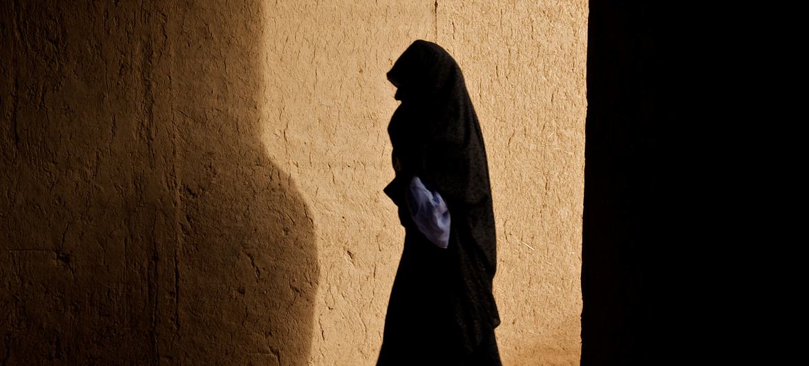 A woman walks through a corridor in a village in Zindajan district, Afghanistan.