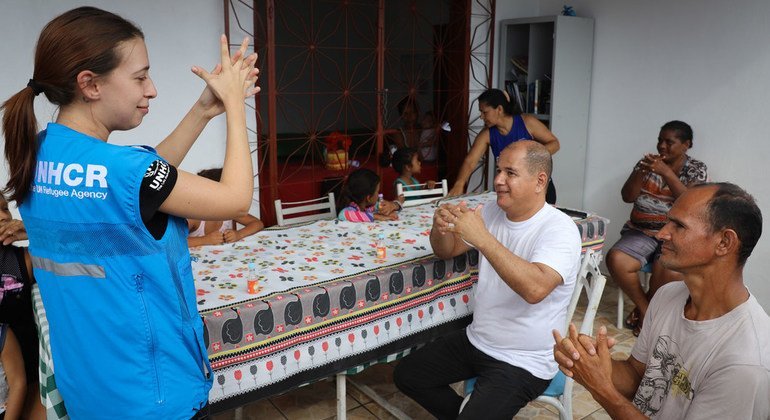 Refugiados y migrantes venezolanos aprenden a usar gel desinfectante repartido por la ACNUR