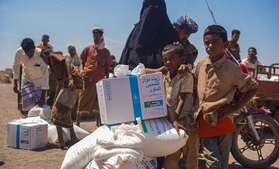 A family receives food aid at a food distribution point in Ras al’Arah in Lahj Governorate, Yemen.